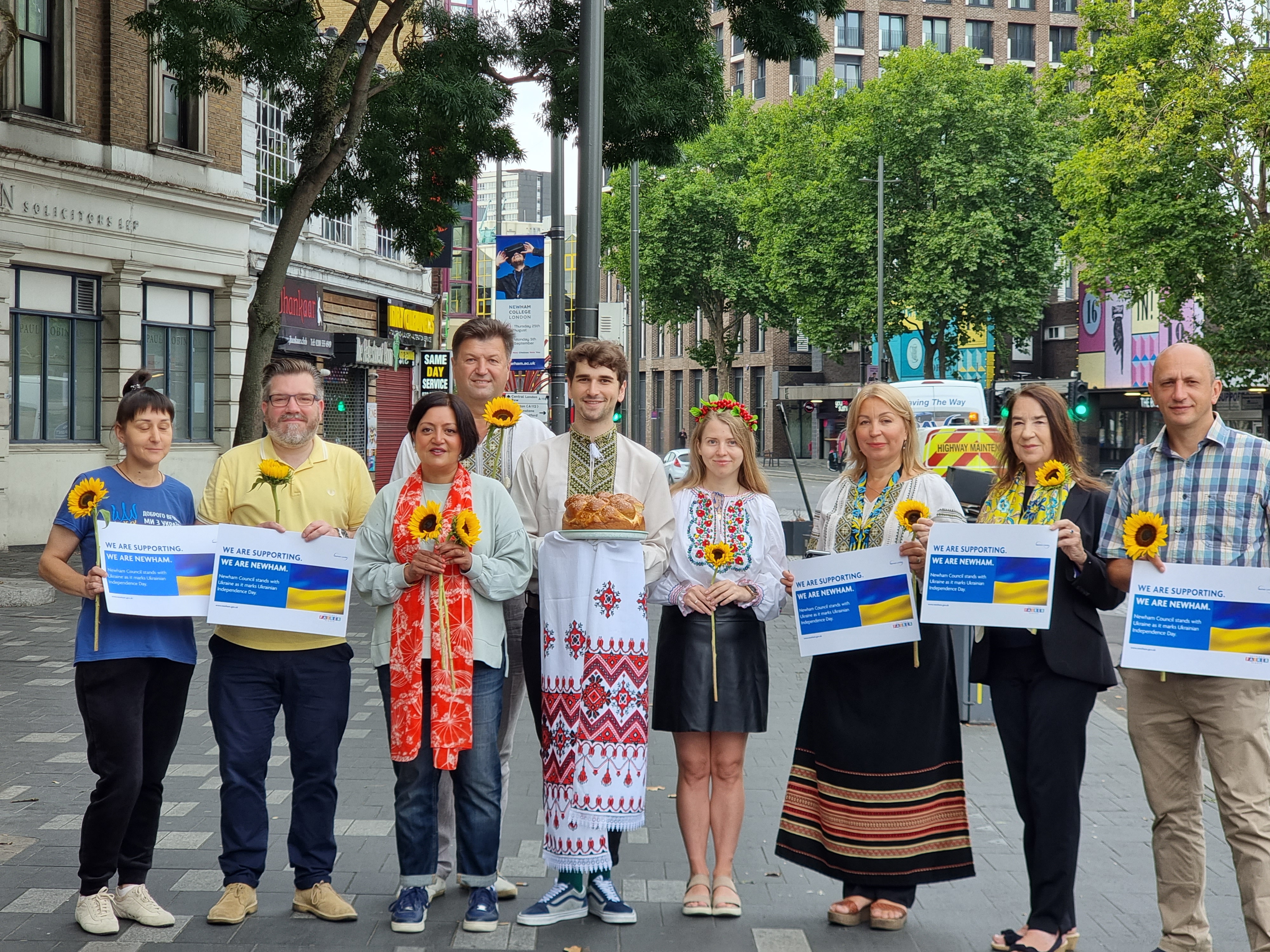 Mayor of Newham holding sunflower with ukranian residents to mark ukranian independence day